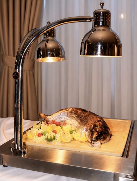 Whole roast fish under a heat lamp
