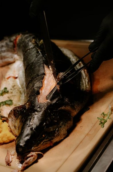 Whole roast fish carved in front of guests