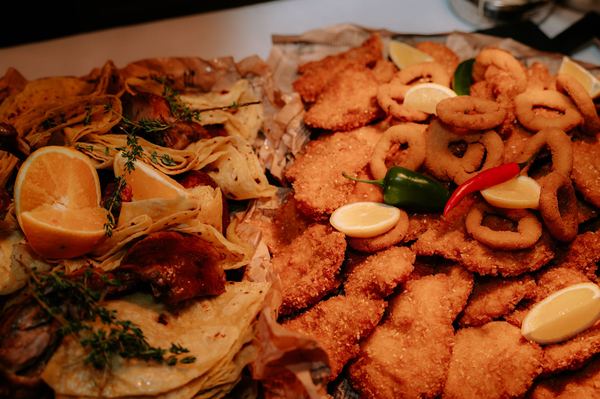 Fried schnitzels and onion rings with lemon on a buffet table